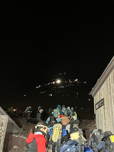 夜中に出発する登山者の列の写真